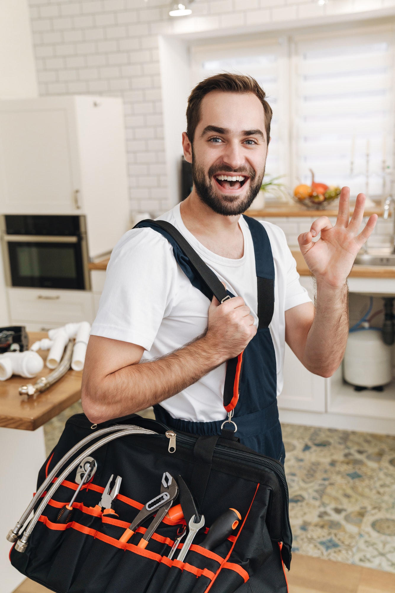 image-of-plumber-man-with-equipment-gesturing-okay-sign-in-apartment.jpg